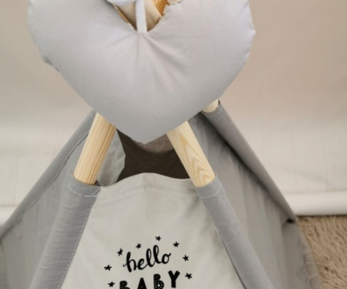 Laps mängimas printsessiteemalises tipi telgis akna ja uste paeltega