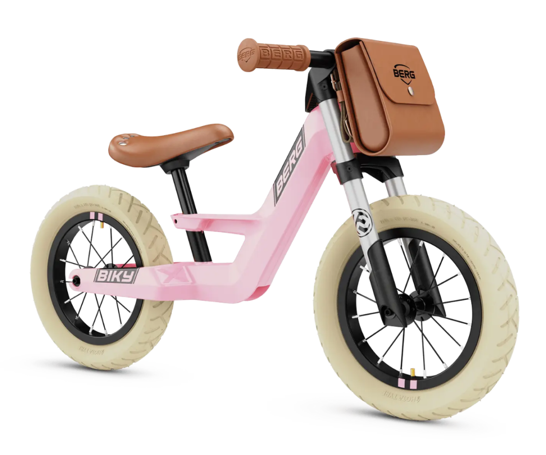 Laps sõitmas Berg Biky Retro roosa jooksurattaga õues.