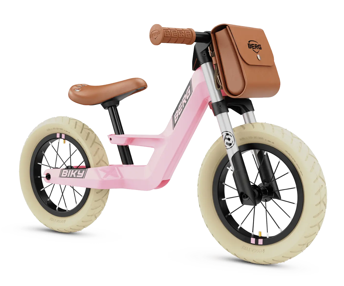 Laps sõitmas Berg Biky Retro roosa jooksurattaga õues.