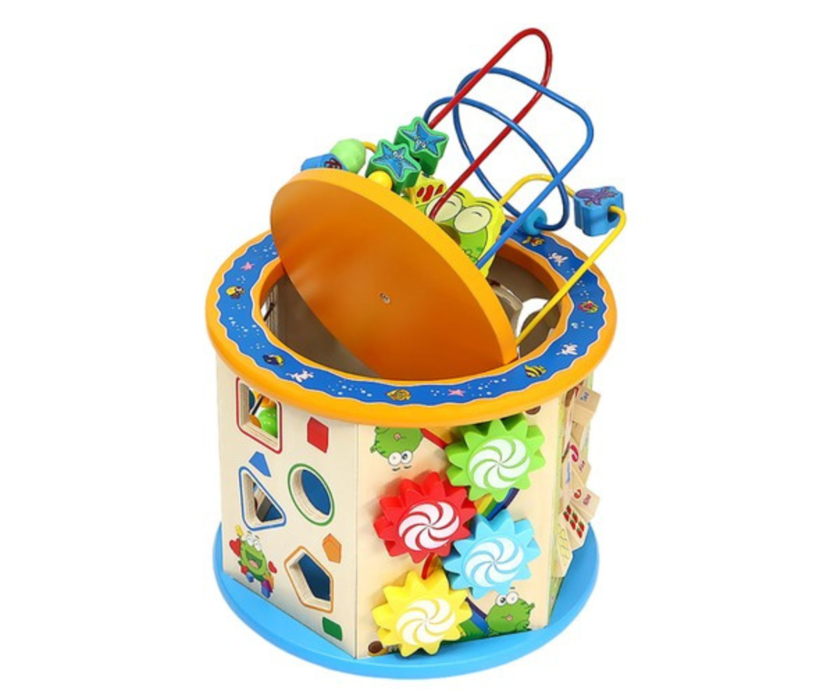 Laps mängimas puidust arendava tegevuskuubikuga