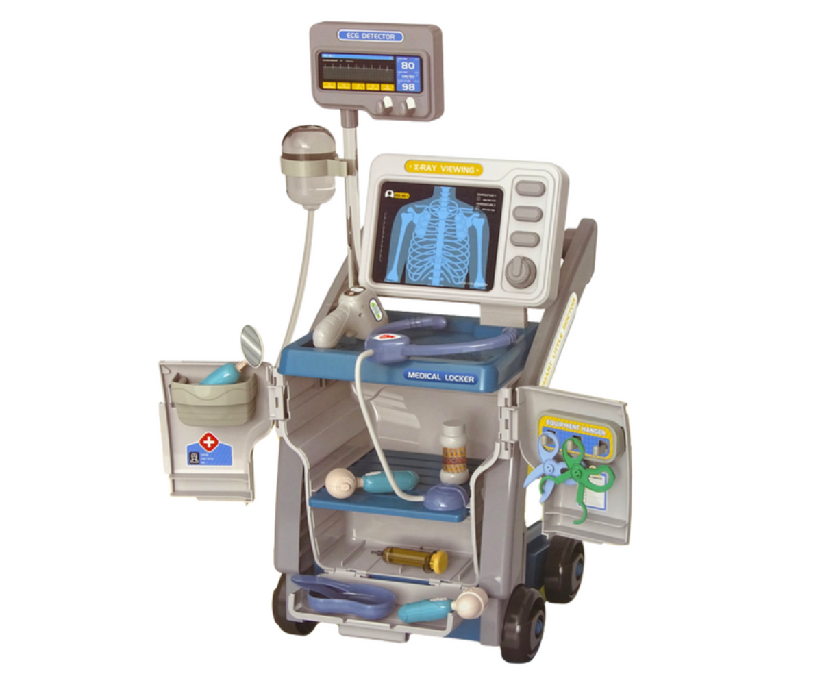 Laps mängib röntgenmonitoriga meditsiinikäru juures, ekraanil nähtavad röntgenpildid.