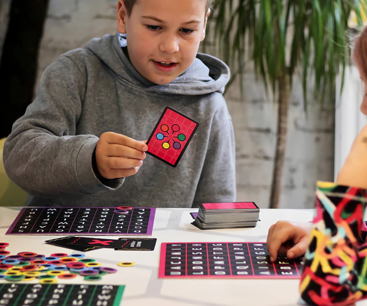 Lapsed ja täiskasvanud mängimas Tactic Sõna Bingo lauamängu