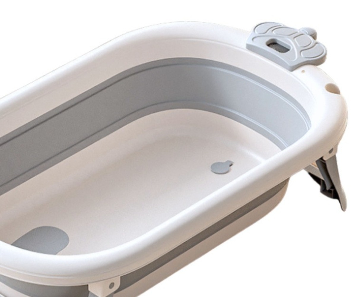 Detailne vaade kokkupandavast beebivannist, sealhulgas madratsist ja termomeetrist.