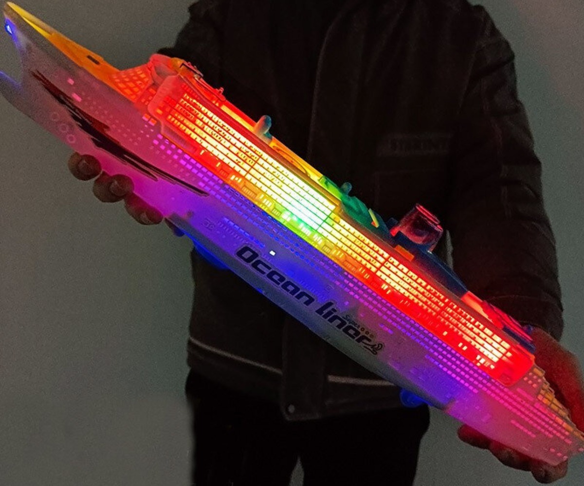 Inimene hoiab Reisilaeva helide ja tuledega – Cruise Ship, millel on säravad tuled.