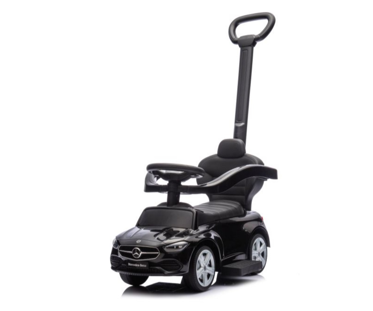 Laps istumas musta Mercedes 3in1 sõiduki peal.