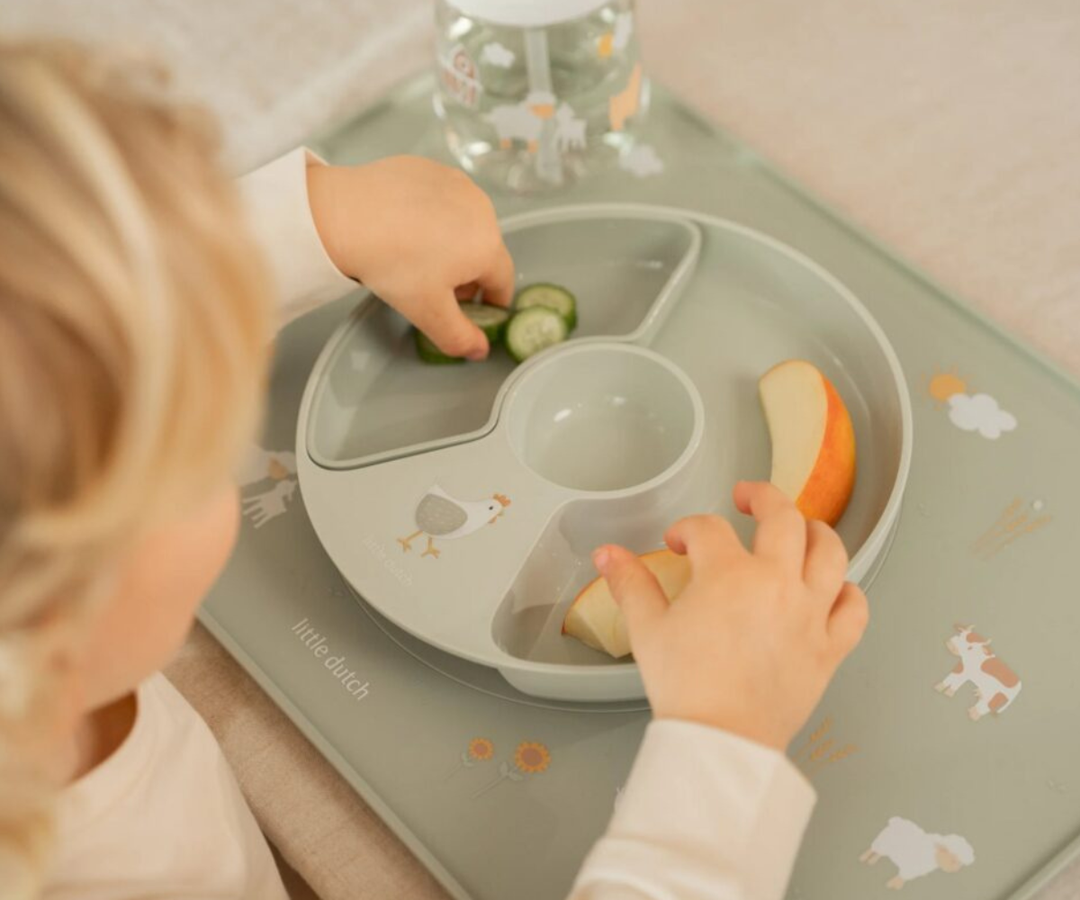 Laps kasutamas Little Dutch söögialust iseseisvaks söömiseks.