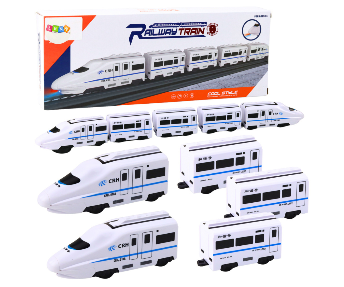 Valge interaktiivne rong nelja vaguniga ja siniste triipudega, liikumas põrandal.