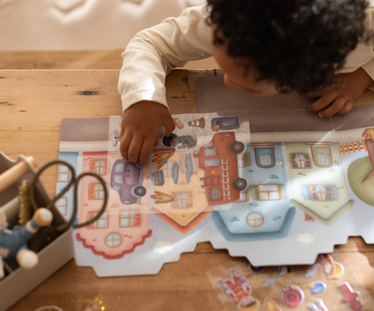 Laps mängimas Little Dutch Jim & Friends kleepsuvihikuga laua taga