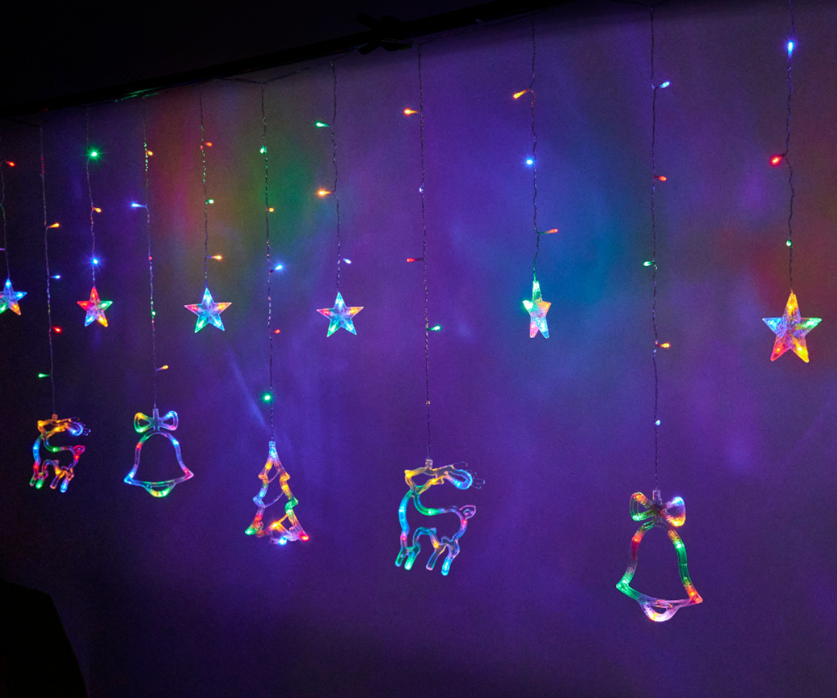 LED-kardin eri värvidega põlemas, nähtavad põhjapõdrad ja rippuvad valgusniidid.