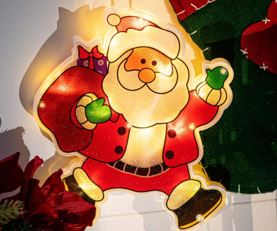 Jõuluvana kingikotiga LED-ornament aknal, kinnitatud iminapaga.