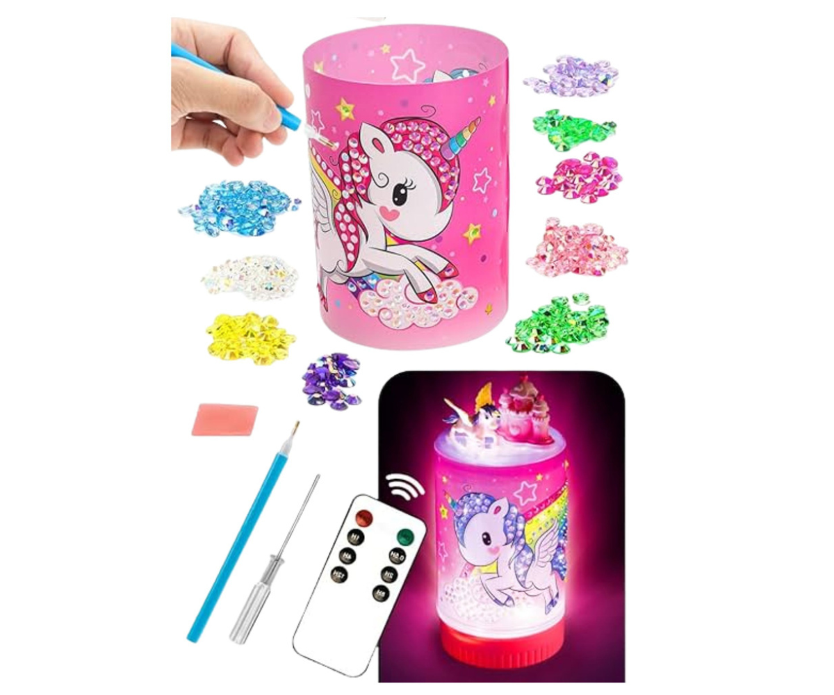 Laps kaunistamas ükssarviku öölampi värviliste teemantkleebistega.