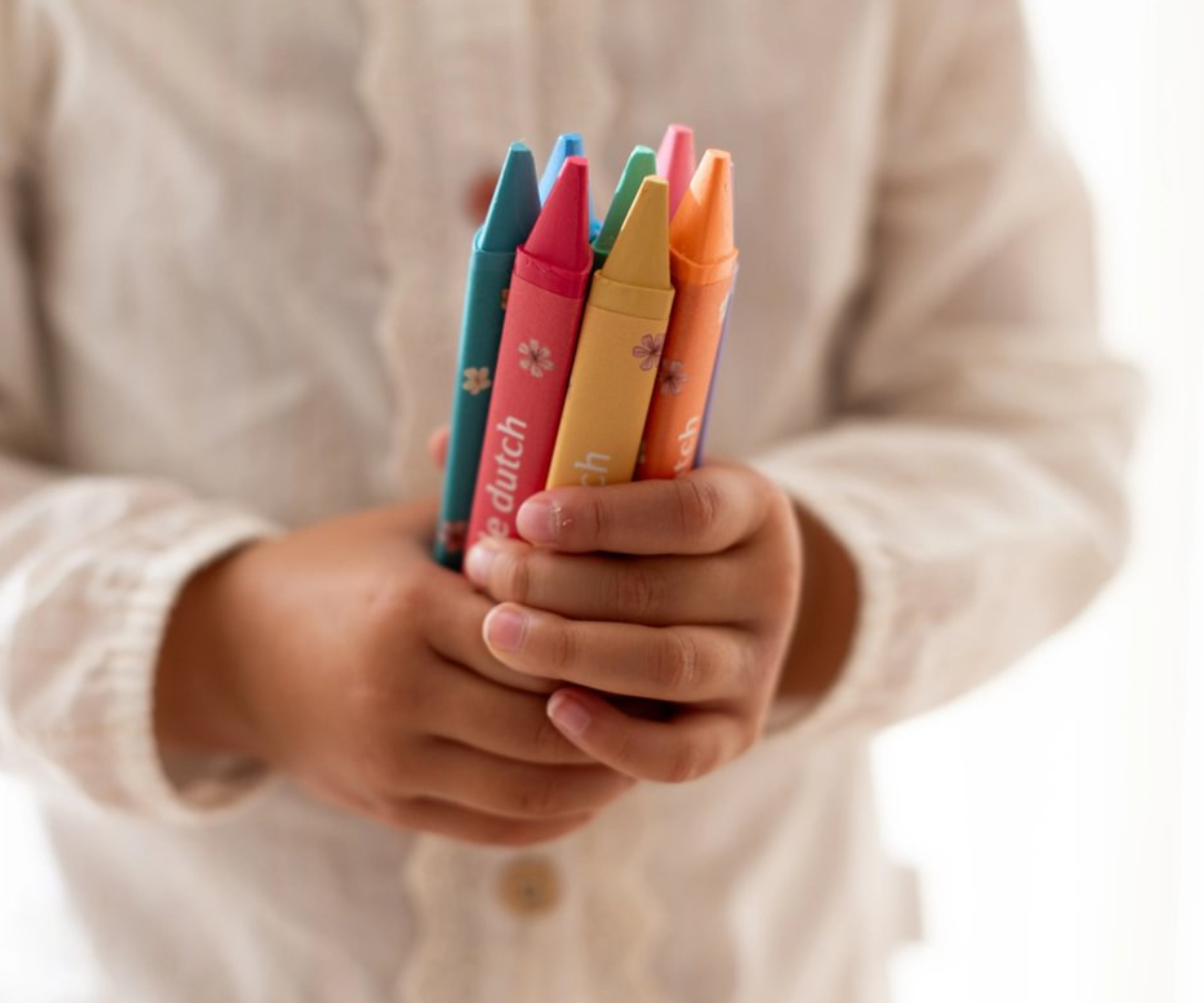 Kaheksa värvilist Little Dutch Rosa & Friends vahakriiti reas laual.