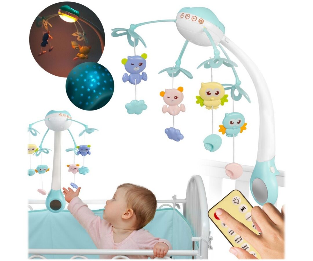 Sinine beebikarussell voodi küljes koos rippuvate mänguasjadega.