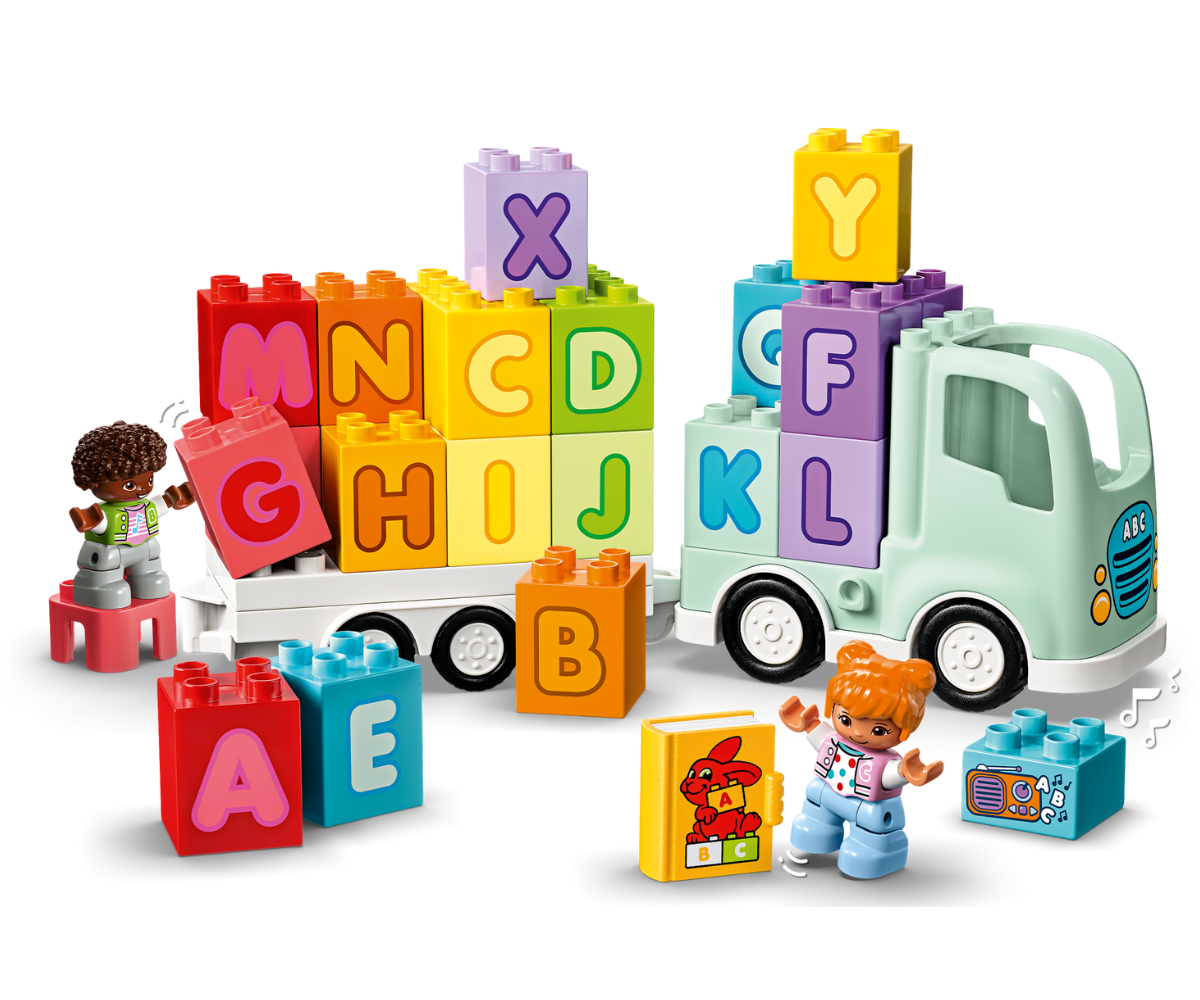 Tähestikveok koos haagisega, mille peale on laotud värvilised täheklotsid.