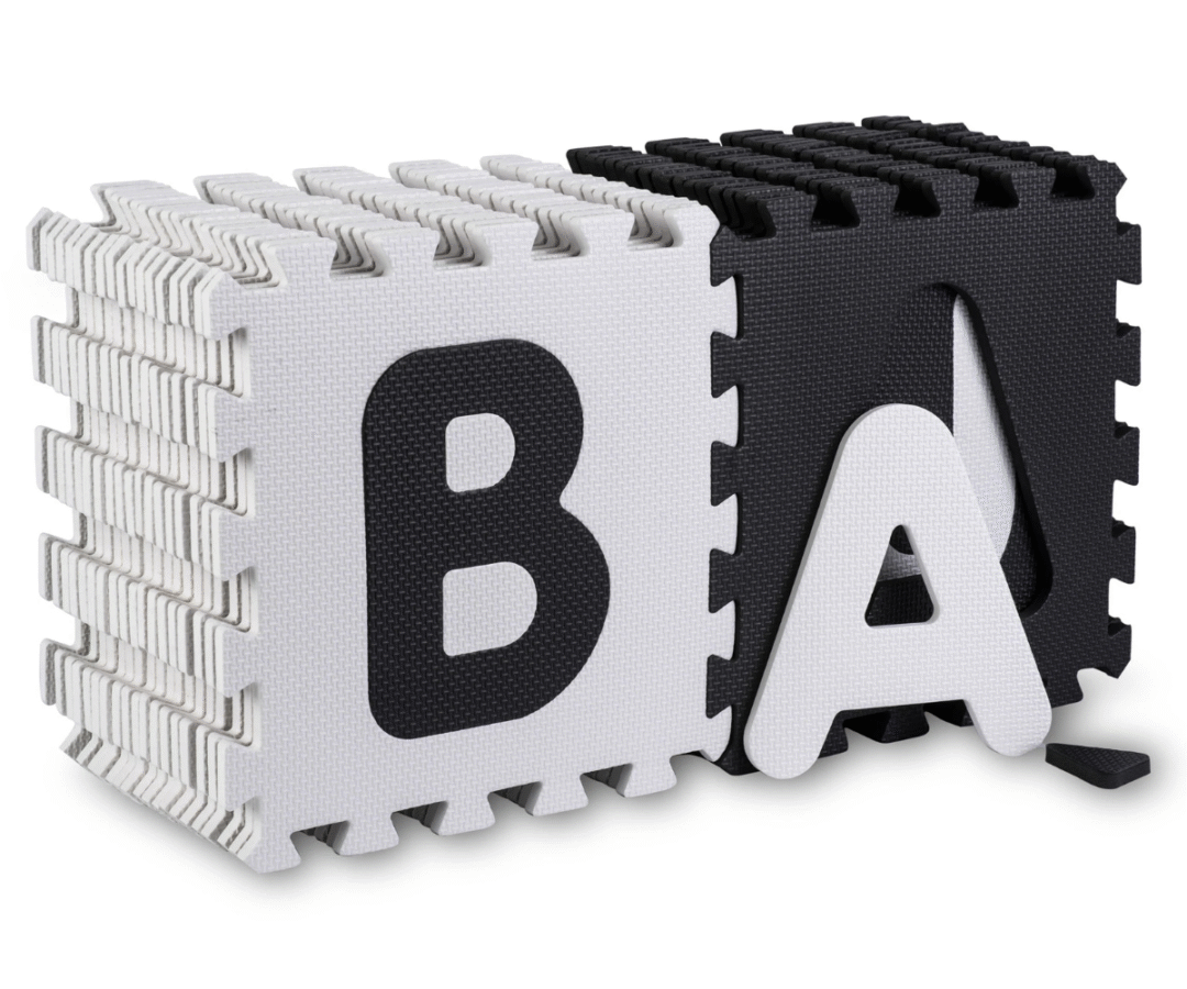 Beebi mängimas pehmel numbritega puslematil, värvilised pusletükid ümberringi.