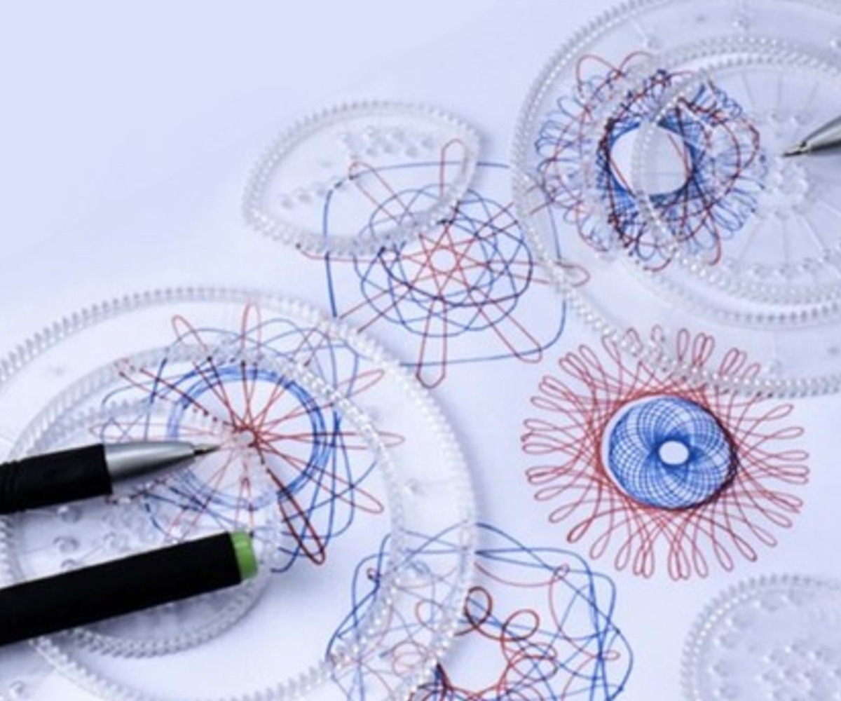 Mustrite joonistamine Loova joonistuskomplektiga – spirograafiga, näha on punaseid ja siniseid jooni.
