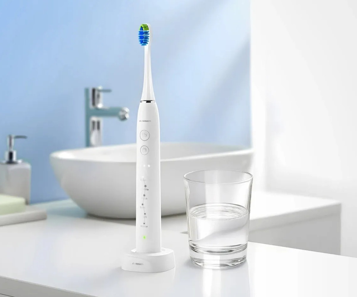 Elektriline hambahari Berdsen – (kuni 50 päeva aku kestvus) valge, seismas vannitoas klaasi kõrval.