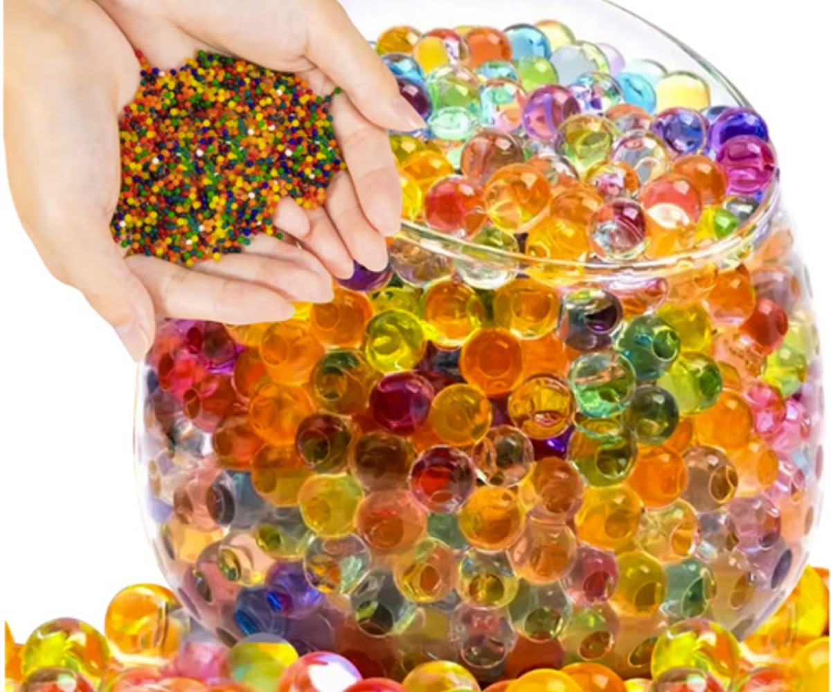 Hüdrogeelkuulid taimedele – mitmevärvilised kätes, värvilised kuulid suures kausis.