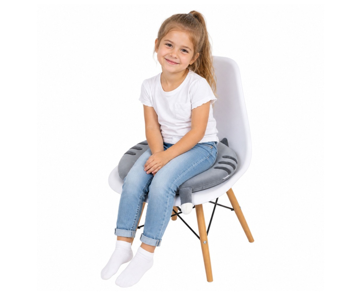 Laps istub pehme toolipadjal Kiisu 40cm – hall, naeratades ja nautides mugavust.