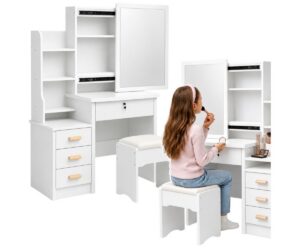 Kosmeetikalaud 80×36×131cm peegli, sahtlite, riiulite ja taburetiga – valge, naine meigib end peegli ees.