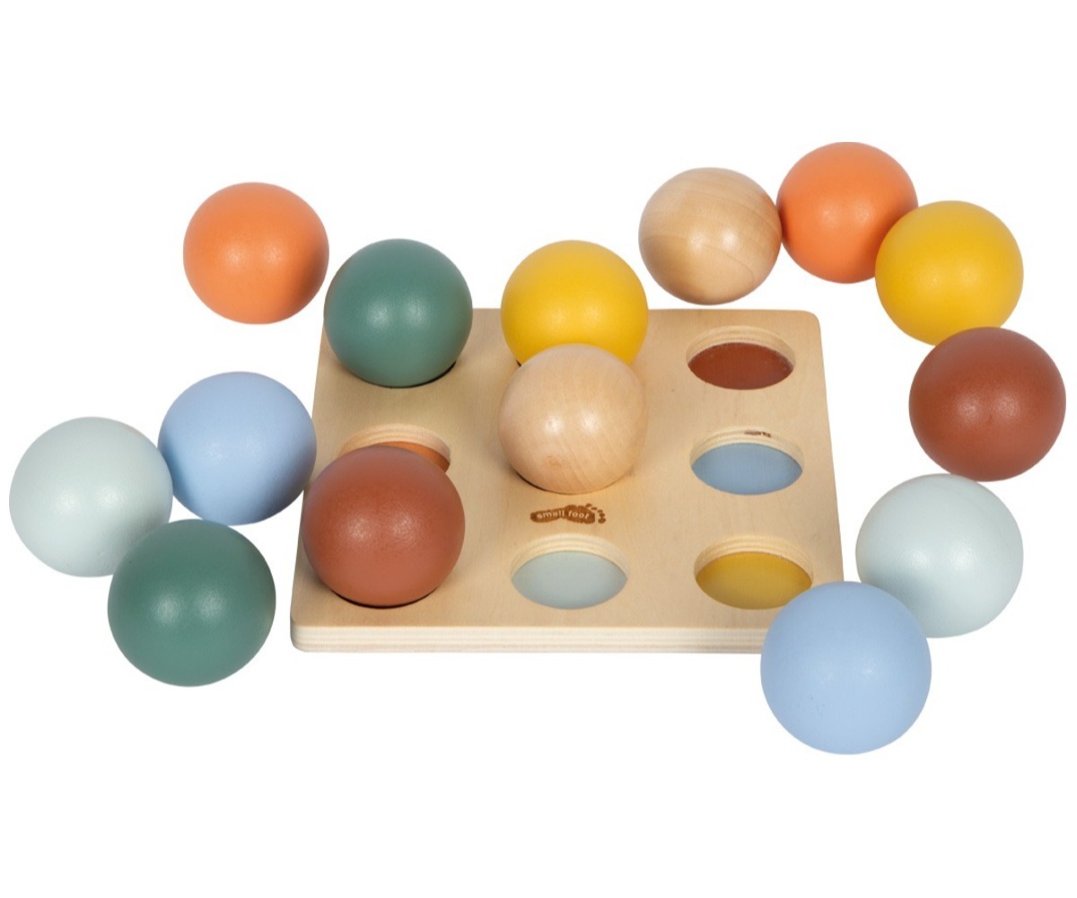 Montessori puidust sorteerimismäng pallidega, kus mitmevärvilised pallid sobivad erinevatesse avadesse.