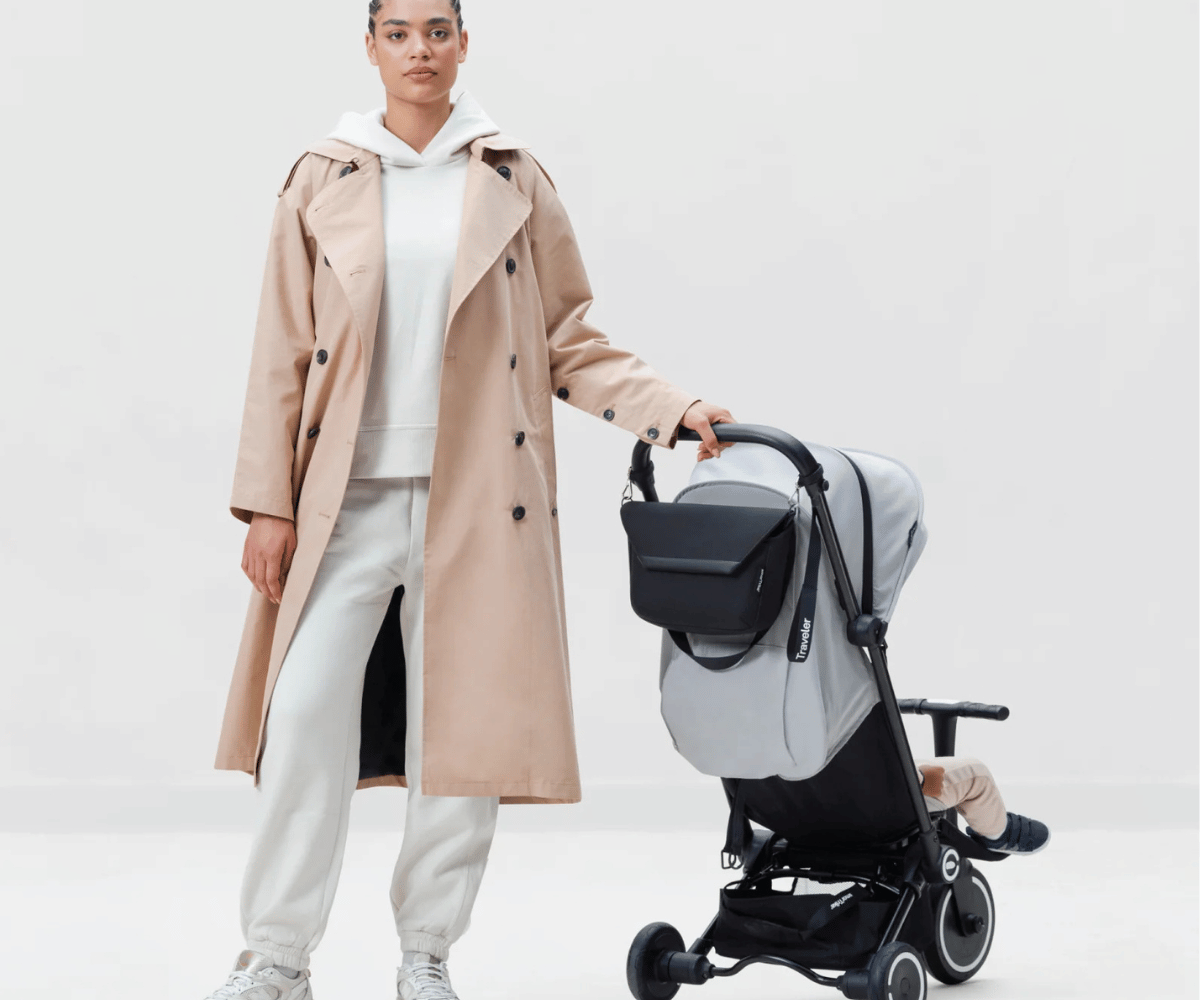 Naine hoiab SmarTrike Traveler käruorganiseerijat - must käru juures